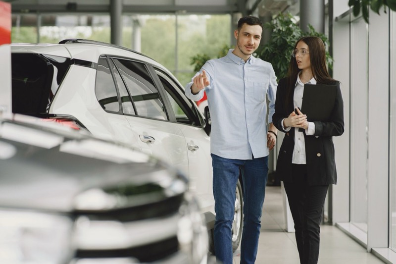 Customer talking with an adviser at a car dealership