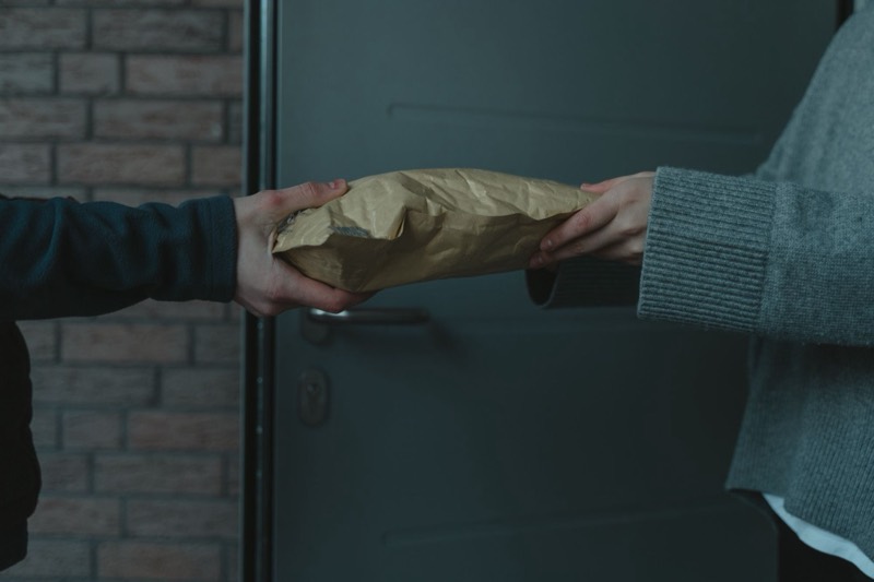 Personal handover of a padded envelope at the front door