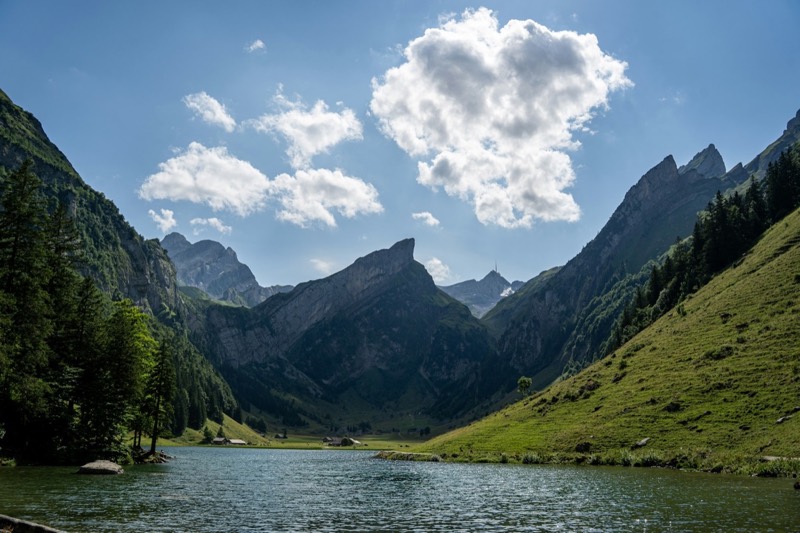 Seealpsee in the Alpstein between steep rock faces and green slopes
