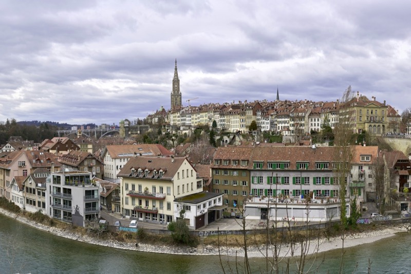 Bern old town above the Aare with the Minster tower under a cloudy sky