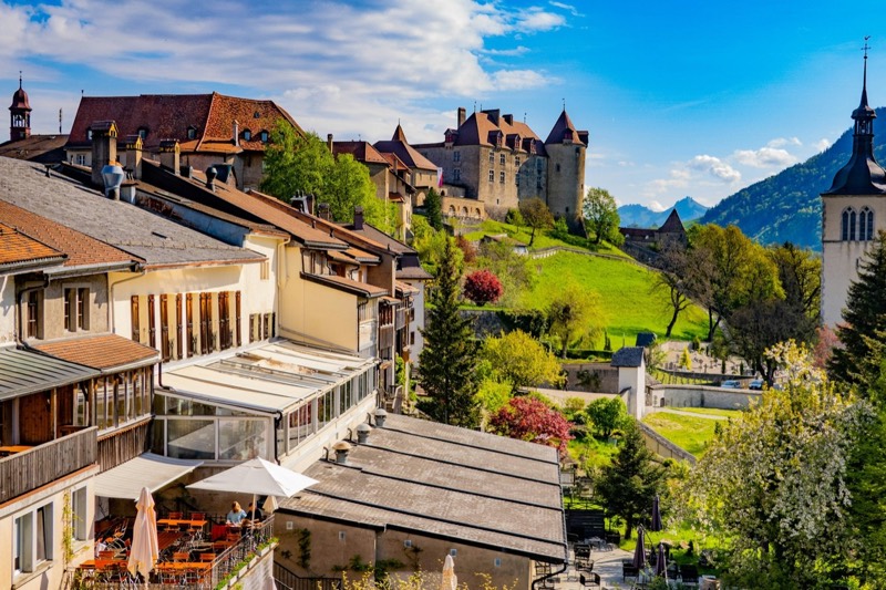 The small town of Gruyères with castle and church, the Alpine foothills behind